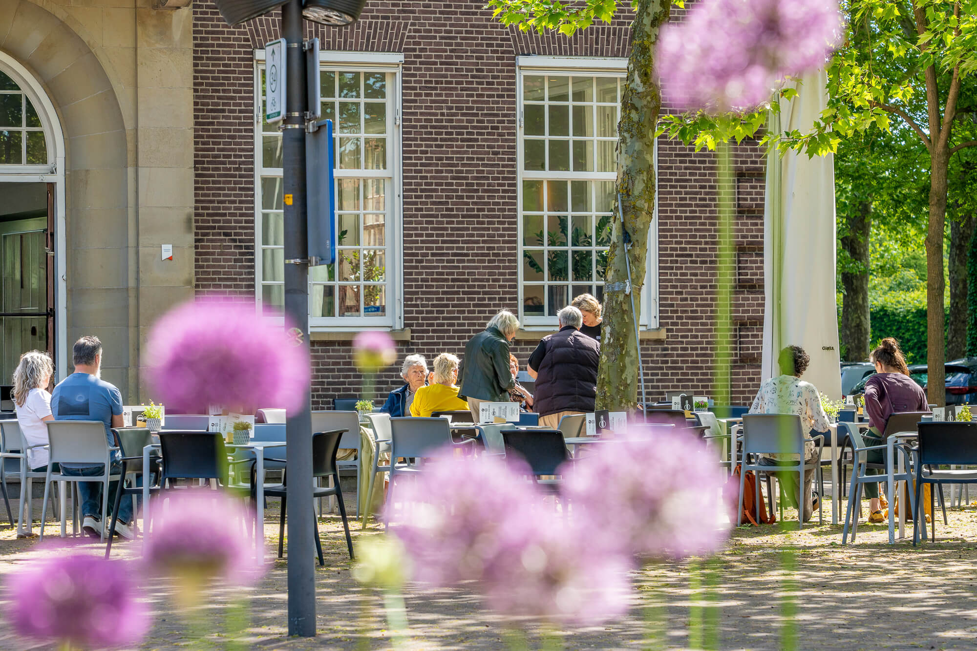 Groepje senioren die buiten genieten van elkaars gezelschap en een gesprek